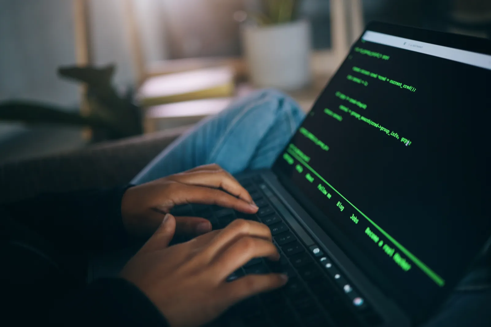 Close detail of hands typing code on a laptop
